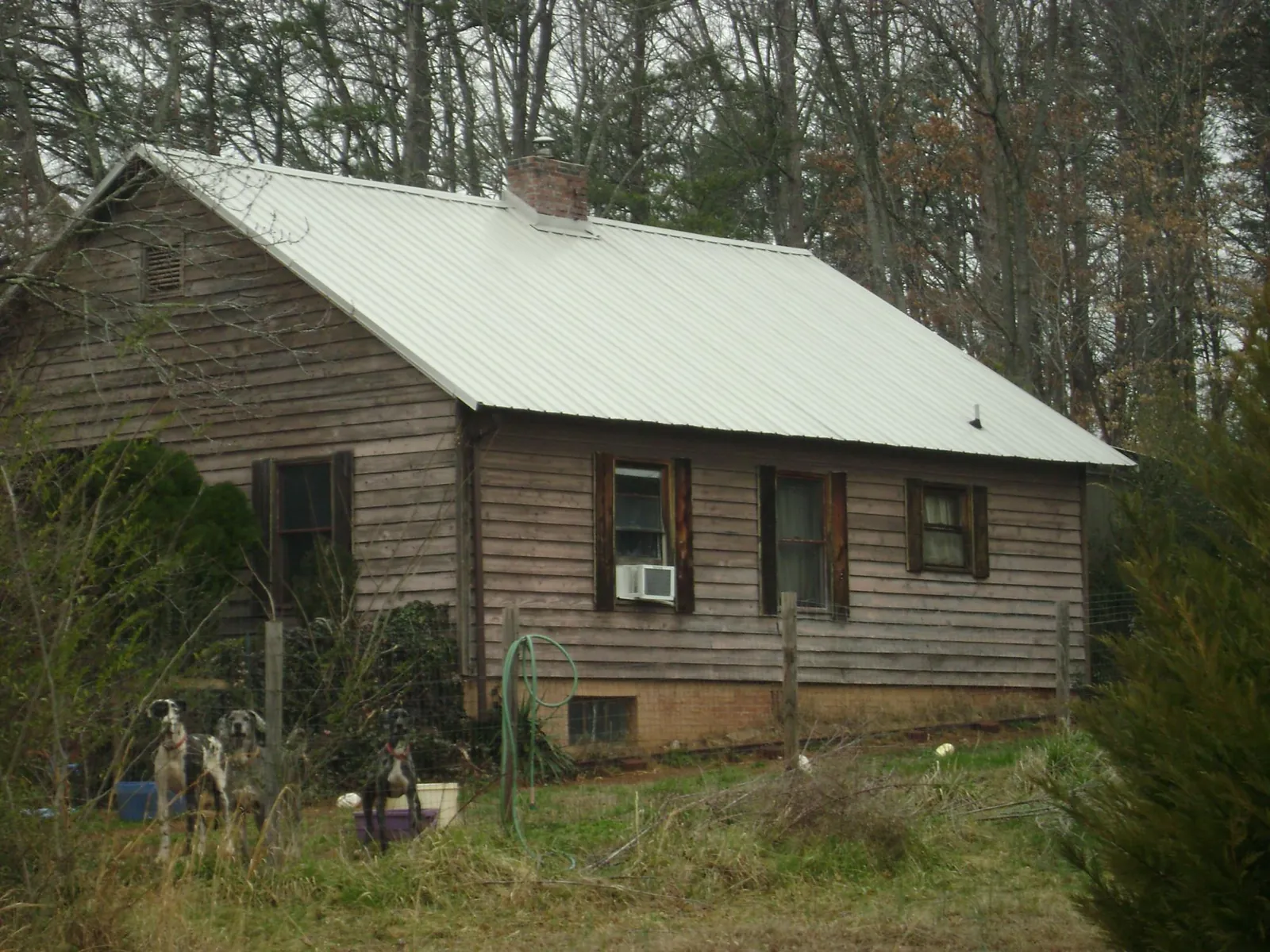 White metal roof on an old wood sided farmhouse, from a Metal Roof Installation job in Hanna